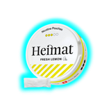 Runde Dose mit Aufschrift 'Heimat FRESH LEMON' und gelb-weißen Streifen, daneben ein weißes Päckchen mit Nikotinbeuteln
