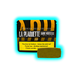 Verpackung mit der Aufschrift 'LA PLAQUETTE JAUNE MOUSSEUX' und einem rechteckigen Haschischblock davor