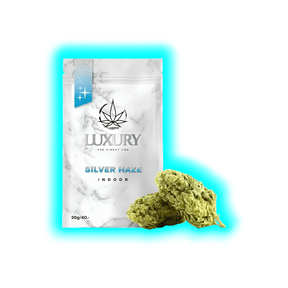 Verpackung mit Marmoroptik und Aufschrift 'LUXURY THE FINEST CBD SILVER HAZE INDOOR 30g/40.-' neben zwei Cannabisblüten