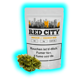 Detailansicht Red City Orange Bud Indoor (5g, 30.- CHF). Produktverpackung mit Warnhinweisen und daneben liegendem Cannabis-Bündel.